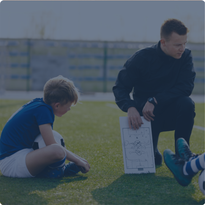 Un entraineur parlant à des enfants